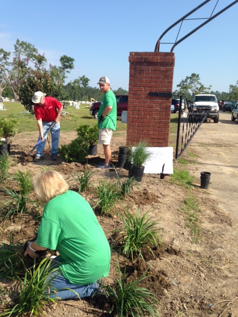 Stephanie Hutchins, chair of Keep Mississippi Beautiful’s board of directors, plants shrubs near one of the cemetery’s entrances with Michael Belote with Southwest Distributors and Forrest Dungan of Columbia.